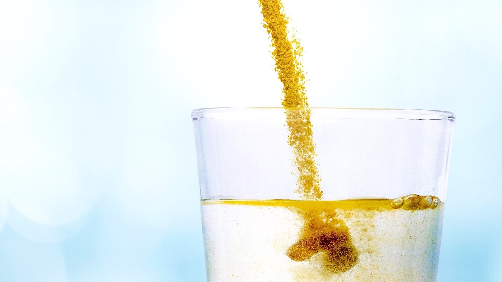 Powder pouring into a glass of water