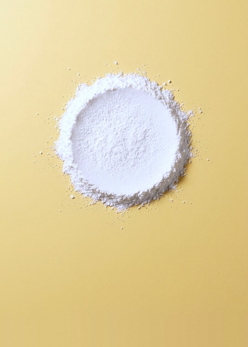 White vitamin B3 (niacinamide) powder sifted into a circle