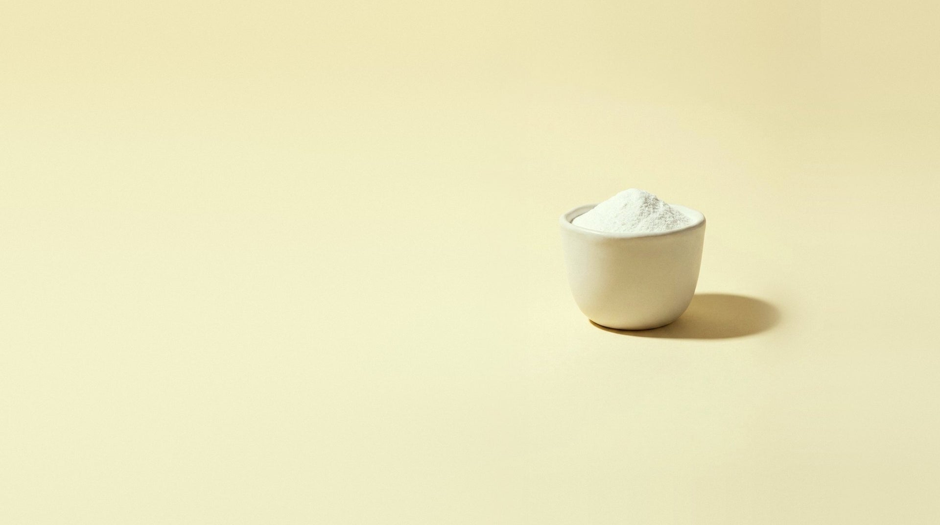 White pantothenic acid powder in a small stoneware cup