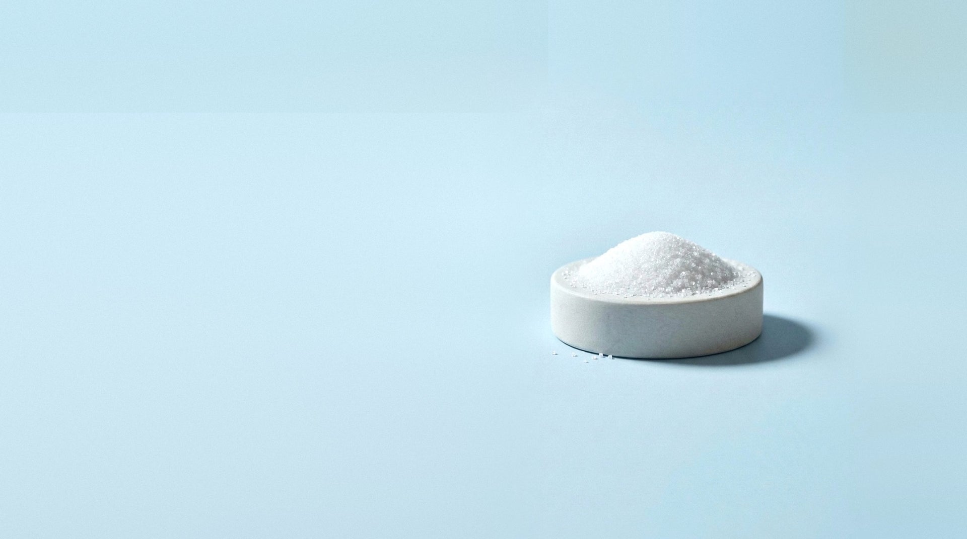 Fine white potassium chloride crystals in a small stone dish