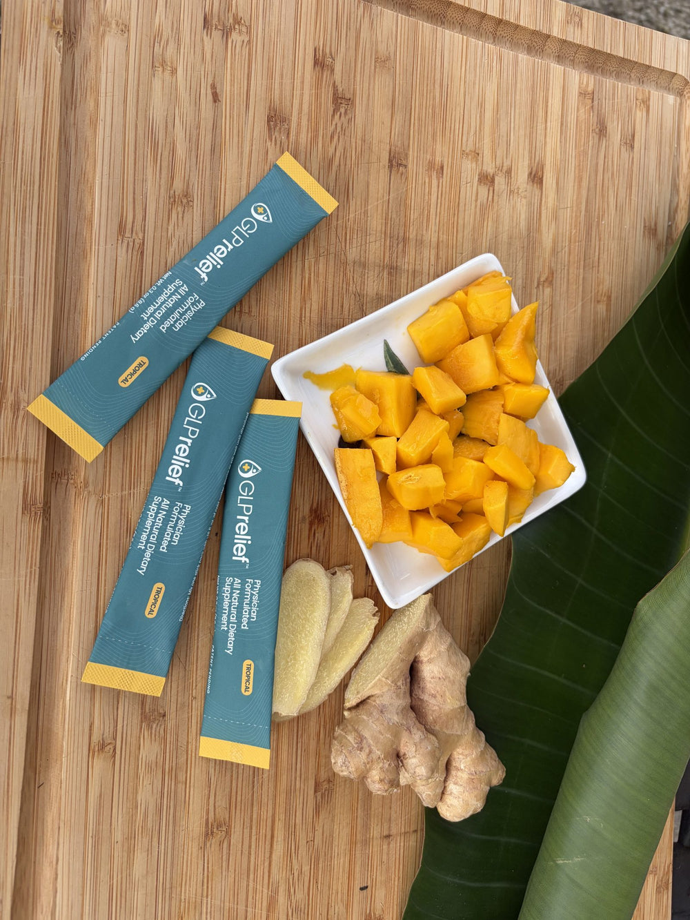 GLPrelief stick packs on a wooden board with mango and fresh ginger