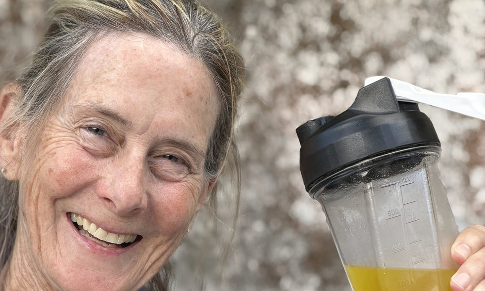Barbara Carroll smiling outdoors with her GLPrelief drink in a shaker bottle